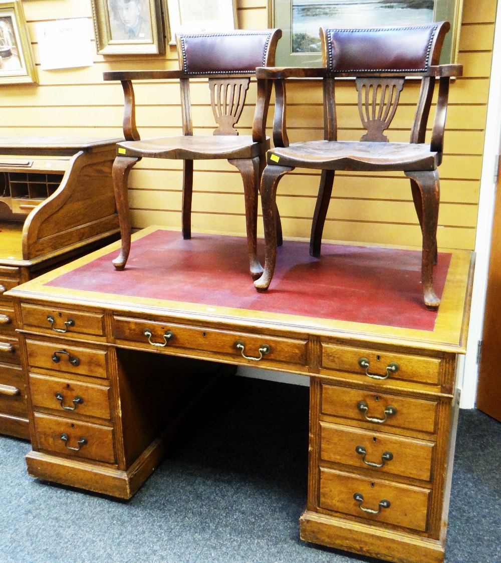 A LARGE VINTAGE OAK PARTNER'S DESK having nine drawers and single cupboard and single drawer verso