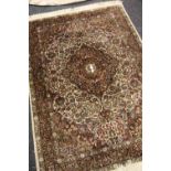 A PERSIAN FLORAL CARPET in dark colours with floral medallion design, 180 x 124cms