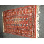 MAINLY RED GROUND INDIAN WOOLEN RUG, lozenge pattern and similar border (worn to centre), 123 x