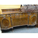 IMPOSING ANTIQUE FLAME MAHOGANY RAIL BACK SIDEBOARD with bowed flanking cupboards and carved