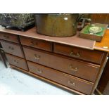 MODERN DARK WOOD RAILBACK SIDEBOARD with seven drawers to the front, 142cms wide