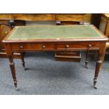 NEAT EDWARDIAN MAHOGANY GREEN LEATHER TOP DESK with two drawers and reeded legs with castors,