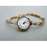 A LADY'S 9CT GOLD ENCASED WRISTWATCH having a circular dial and with expanding 9ct gold bracelet,