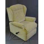 A LIGHT FLORAL UPHOLSTERED AND RECLINING EASY CHAIR