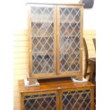 A SET OF THREE POLISHED BOOKCASES, floor standing, each with two leaded and latticed glazed doors