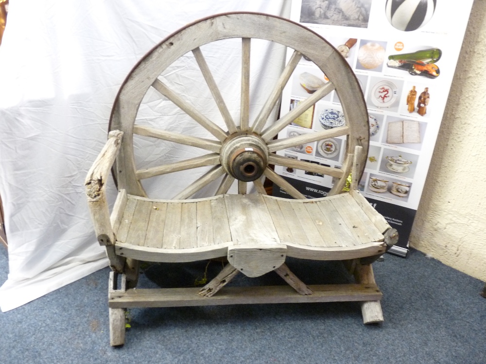 A VINTAGE RUSTIC WAGON WHEEL GARDEN BENCH, 125cms height, 125cms width, 44.5cms seat depth (some