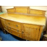 A WELL PRESENTED BLONDE OAK RAIL BACK SIDEBOARD, the shaped front having three central drawers and