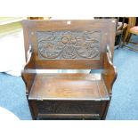 A SMALL POLISHED MONKS BENCH with carved lions mask lid and carved front to a box seat