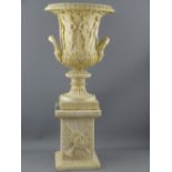 TWIN HANDLED URN AND PLINTH, wide necked urn with classical relief on a square alabaster base, 55cms