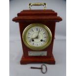 PRESENTATION MANTEL CLOCK with Roman numerals, set enamel dial and bell strike movement, the front