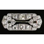 AN ART DECO DIAMOND BROOCH with open centre surrounded by twenty four diamonds, the two largest