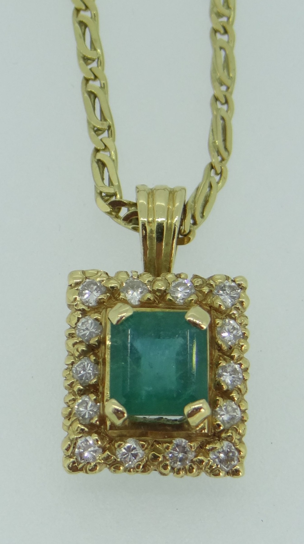 YELLOW METAL (BELIEVED 18CT GOLD) EMERALD & DIAMOND PENDANT ON 18CT GOLD CHAIN, the central