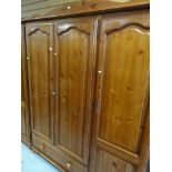 HONEY PINE TRIPLE WARDROBE with drawer base, together with a matching two drawer dressing table