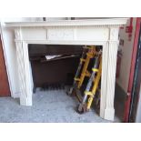 LARGE WHITE PAINTED WOODEN FIRE SURROUND with classical decoration and Corinthian column sides,