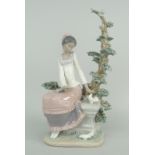 LLADRO MODEL OF AN AFRO-CARIBBEAN GIRL IN PINK DRESS seated against a fir tree with doves