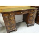 GOOD REPRODUCTION SERPENTINE DESK having brass handles, tooled and leather top, 75cms h x 115cms w