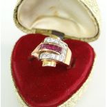 YELLOW METAL DIAMOND & RUBY LADIES RING, the four central rubies surrounded by horseshoe of