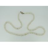 STRING OF NATURAL PEARLS WITH YELLOW METAL CLASP IN BOX.