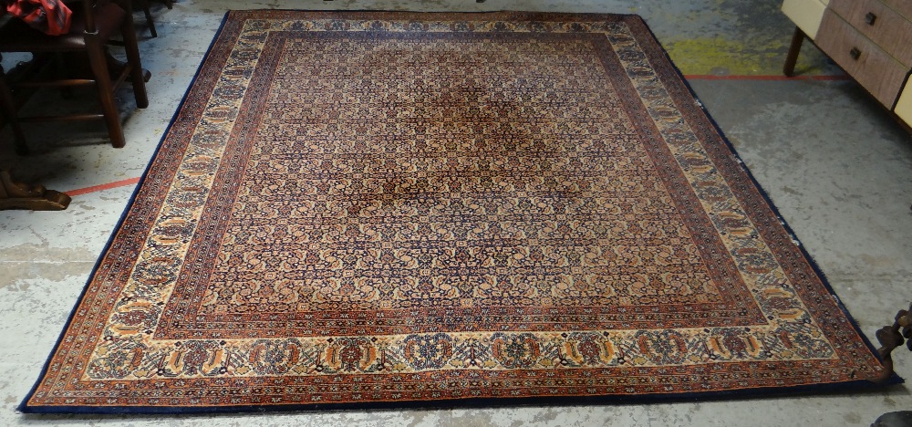 LARGE MAINLY BLUE GROUND PERSIAN WOOLEN RUG with repeating central pattern and contrasting border (