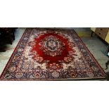 LARGE MAINLY RED & BLUE GROUND PERSIAN WOOLEN RUG with floral centre decoration and border, 325 x