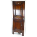 ANTIQUE STANDING TWO STAGE CORNER BLIND-CUPBOARD the top section with panelled door in elm, turned
