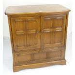 ERCOL TV CABINET with base drawer and carved panel design, 92cms wide