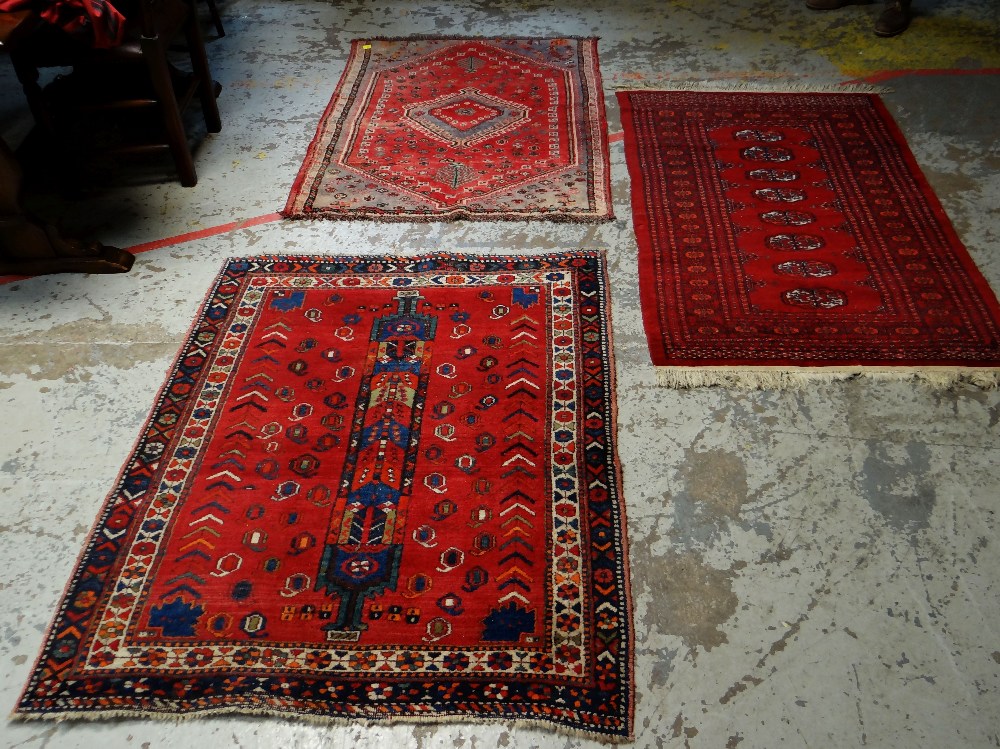 THREE VARIOUS PERSIAN WOOLEN RUGS, all mainly red ground with various patterns, 130 x 102cms, 150