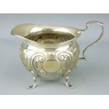 SILVER CREAM JUG - bowl shaped body on four shell supports with scrolled handle and scrolled and