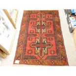 BALUCHI RUG, red ground single bordered with gothic type central pattern, 137 x 87cms