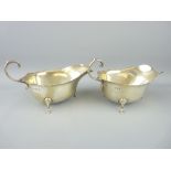 PAIR OF ASPREY SILVER CREAM OR SAUCE BOATS - each on three pad feet with plain bodies, London