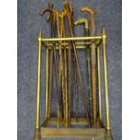 VINTAGE BRASS & CAST IRON EIGHT SECTION STICK STAND and a quantity of walking sticks and canes