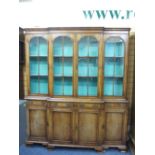 EARLY 20TH CENTURY REPRODUCTION WALNUT BREAKFRONT CABINET BOOKCASE having four upper glazed doors