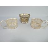 THREE SILVER HOLDERS, all pierced including a 4.5cms H bowl/dish holder, 7cms diameter, London