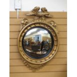 A REGENCY STYLE GILT CONVEX WALL MIRROR with eagle cresting and bobble detail, (some restoration