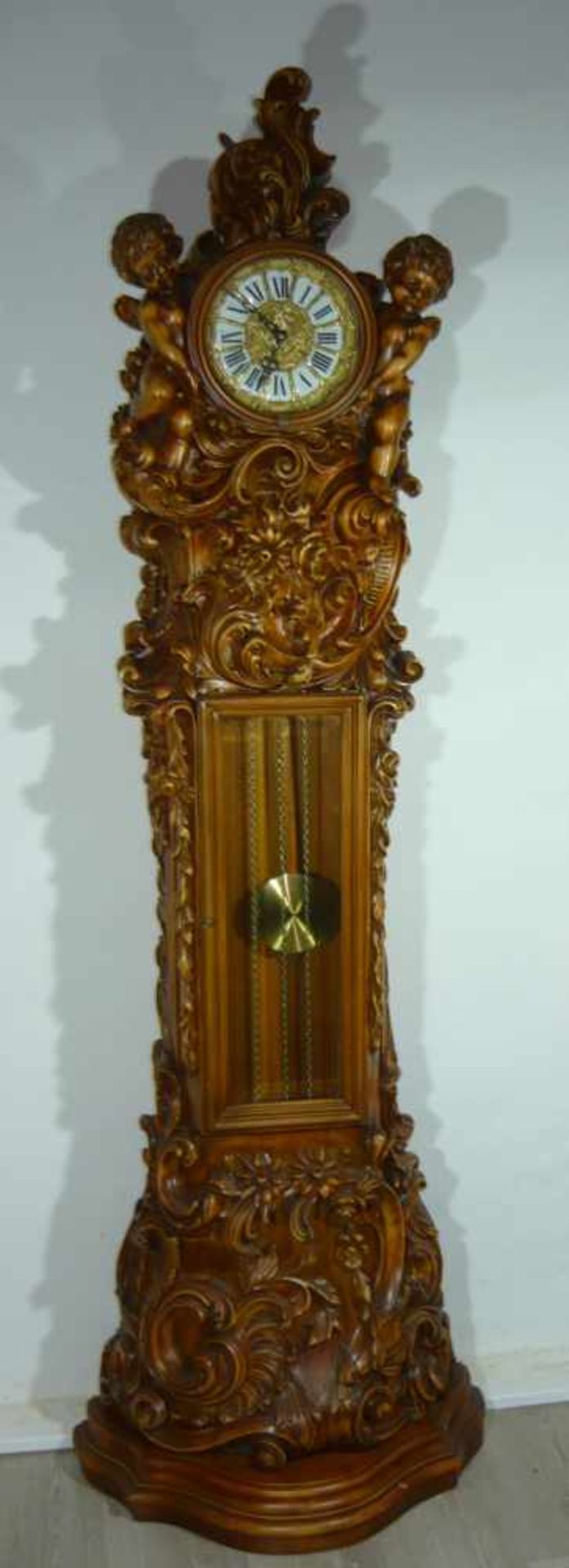 Reich verzierte Standuhr mit Putten. Pendel u. Gewicht vorhanden. H. ca. 202 cm.Rich ornamented