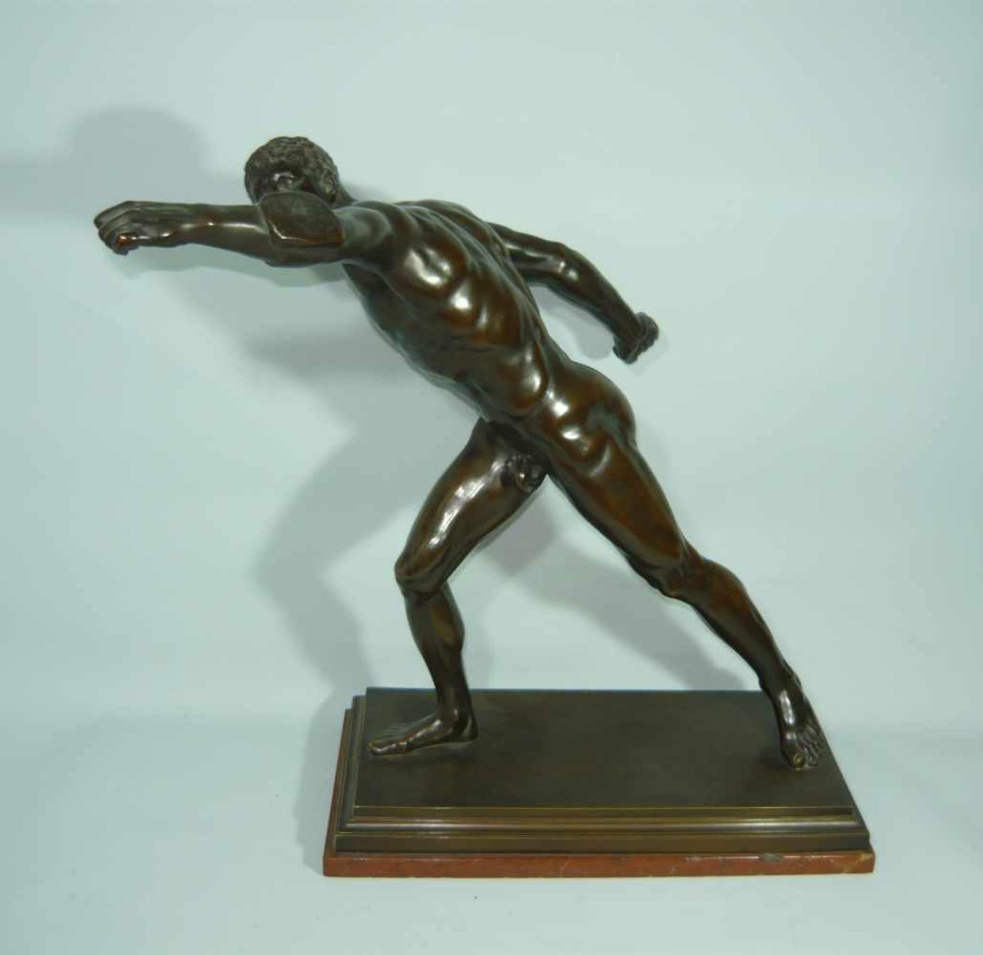 Unbek. Künstler. Darstellung eines nackten Athleten. Bronze auf Steinsockel. Ges. L. ca. 76 cm.