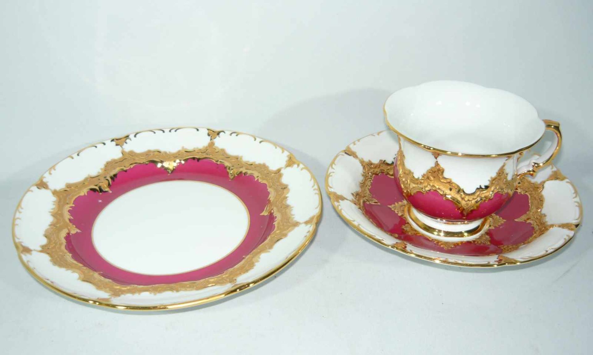 Meissen (Schwerter). Rotes 3-teiliges Prunkkaffeegedeck, B-Form. Obertasse II. Wahl, Teller I. Wahl.