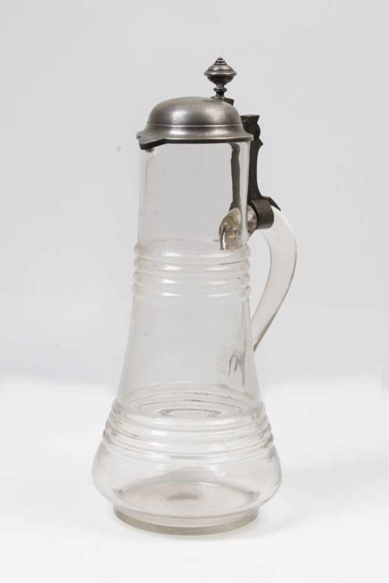 Großer Saftkrug.19. Jh. Farbloses, mundgeblasenes Glas. Zinndeckel. H: 35 cm.