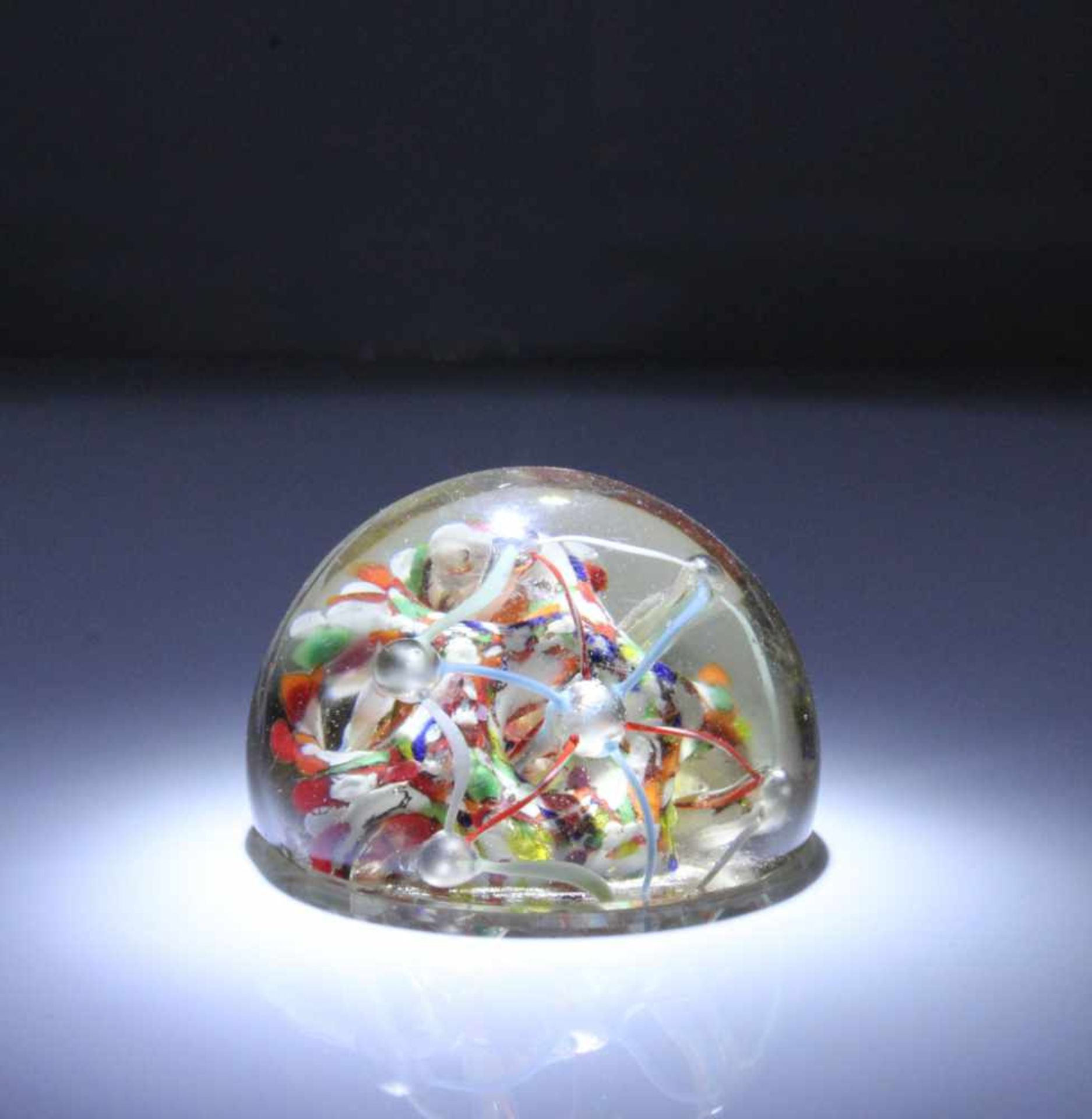 Paperweight.Farbloses Glas. Halbkugelig mit buntgespengelter Rosette und Bogenornamente. H: 6 cm.