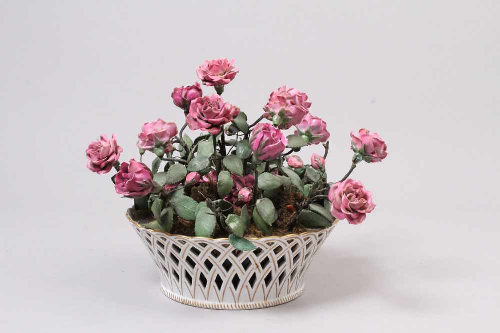 Porzellanschale.20. Jh. Durchbruchkorb, gefüllt mit eingesteckten Rosenblüten aus Porzellan,