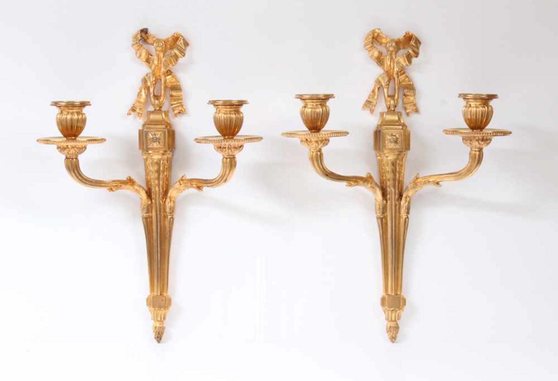Paar Appliken.Frankreich, 19. Jh. Bronze vergoldet. Zweiarmig, Schleifenbekrönung. Louis- XVI- Stil.