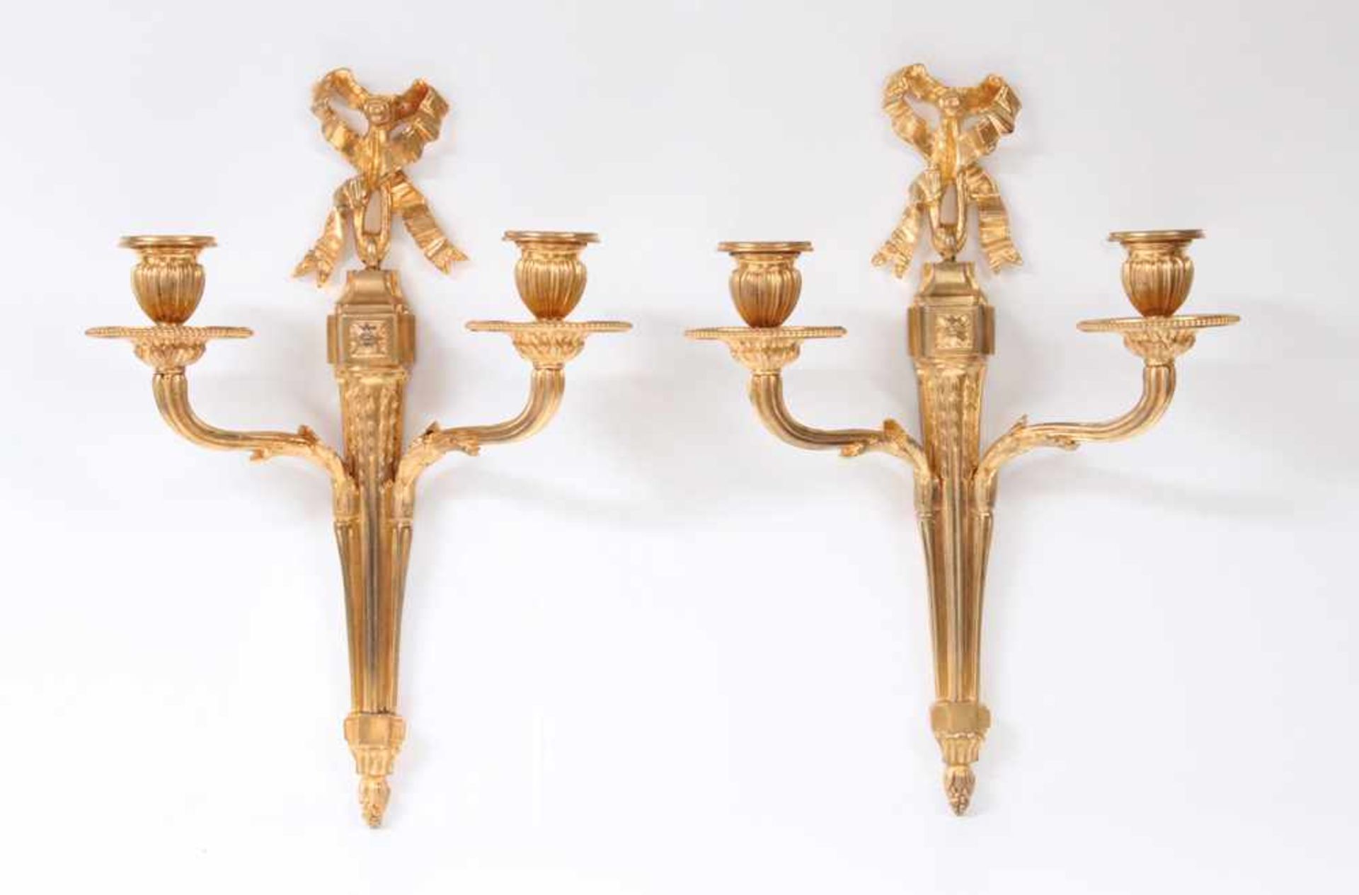 Paar Appliken.Frankreich, 19. Jh. Bronze vergoldet, zweiarmig mit Schleifenbekrönung. H: 36 cm.