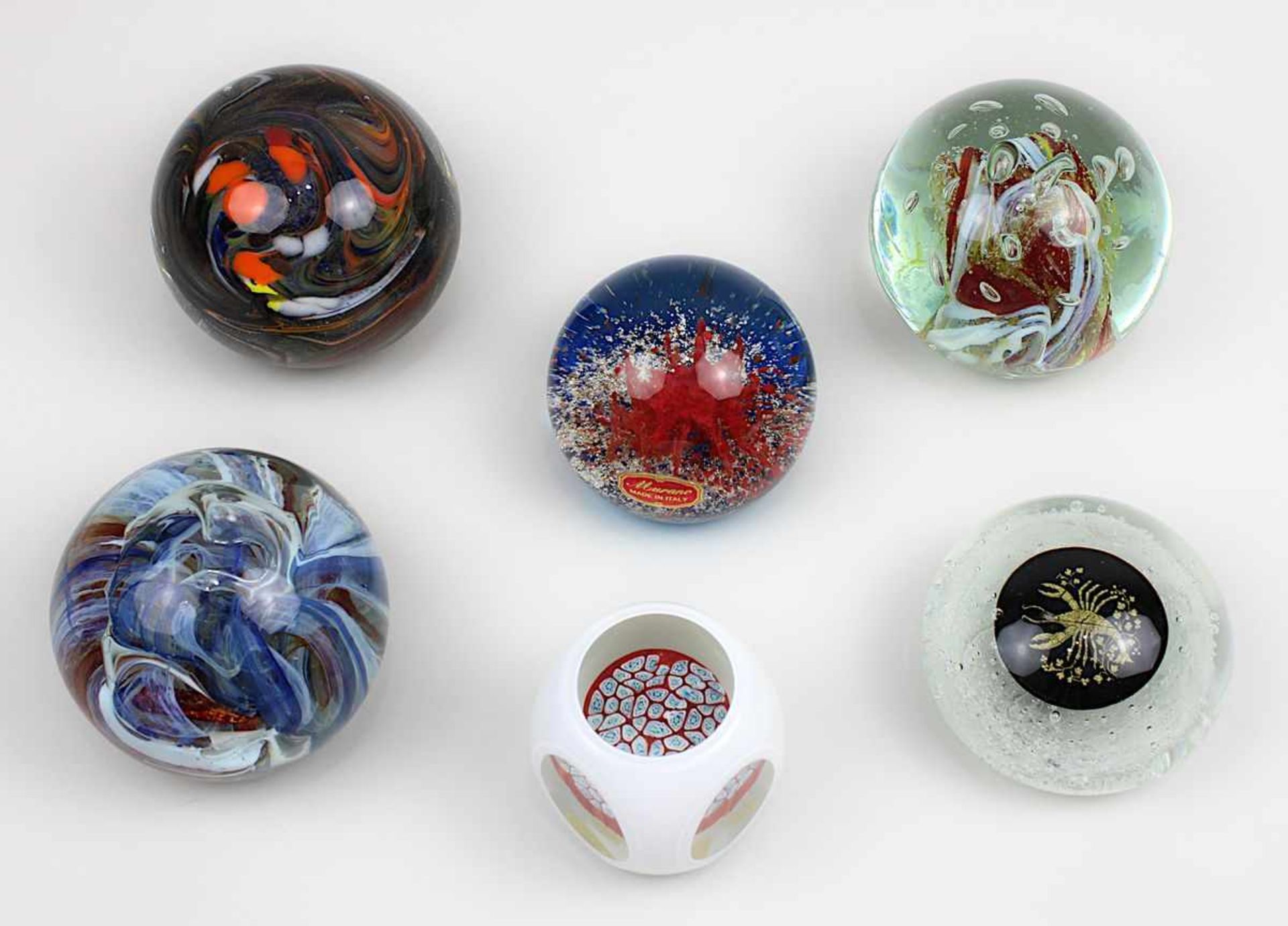 6 Paperweights, 2. H. 20. Jh., davon 3 mit eingeschmolzenen Farbschlieren, eines mit Sternzeichen