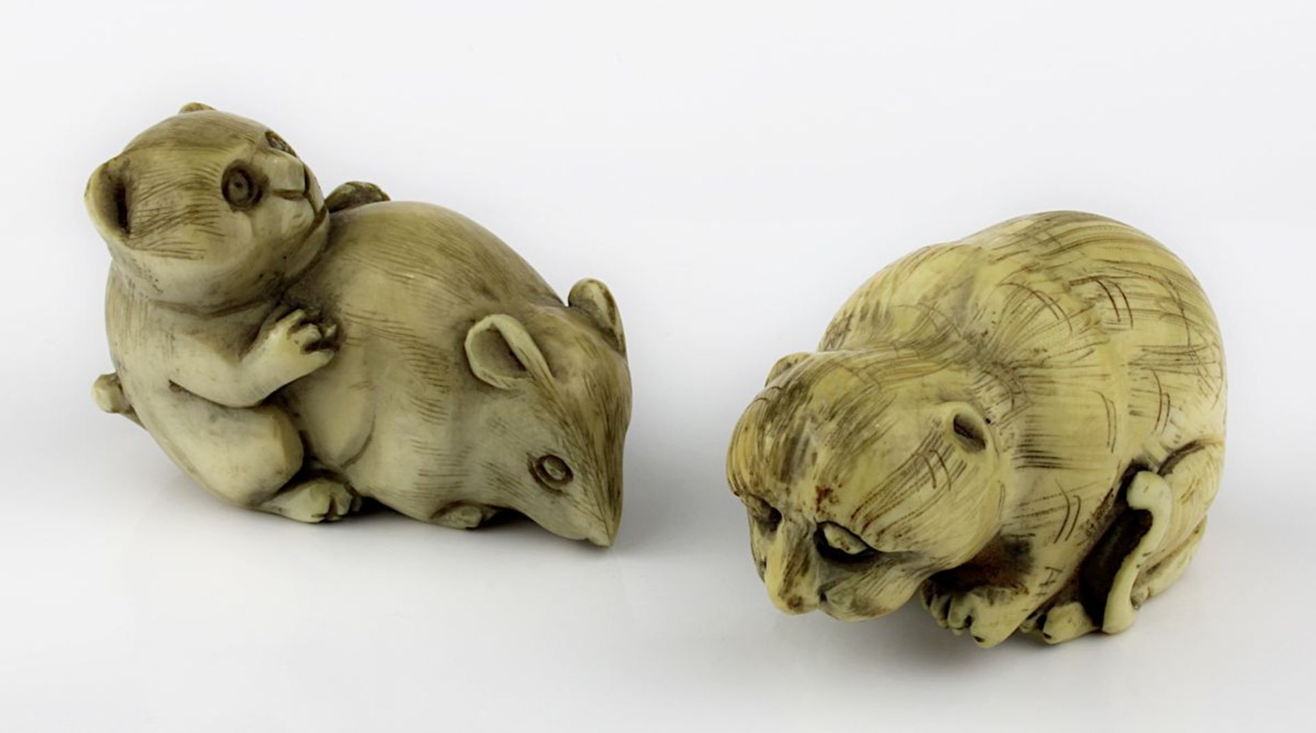 2 Netsukes aus Elfenbein, Ratte mit Kätzchen sowie kauernde Katze, Japan 1. H. 20. Jh., jew. im