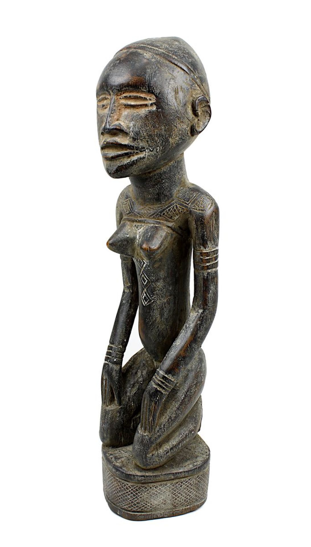 Kniende weibliche Figur wohl der Yombe, D. R. Kongo, schweres Holz geschnitzt und mit Resten von