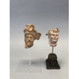 GRECE. Deux têtes masculines de divinité. Terre cuite. H : 8 à 10 cm. - -