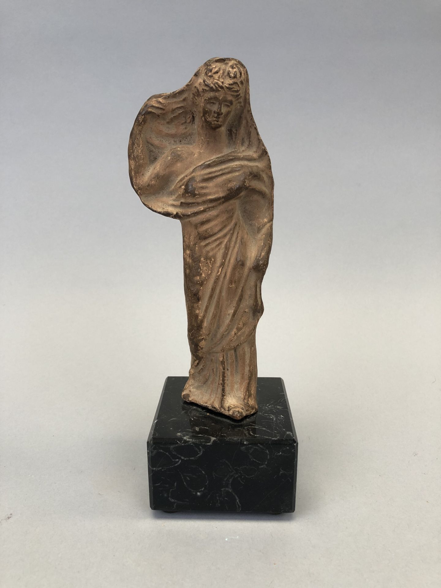 GRANDE GRECE. Statuette de Vénus se dévoilant. Terre cuite. H : 17 cm. Socle. - -