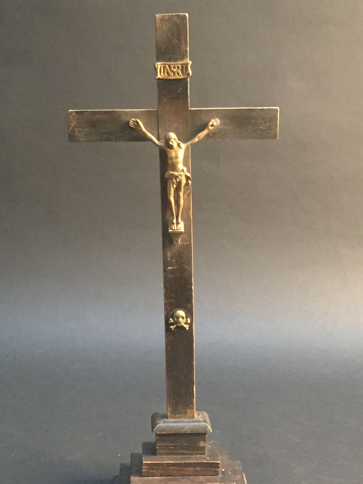 Crucifix de bronze, croix en bois noirci reposant sur une base à trois degrés. [...]