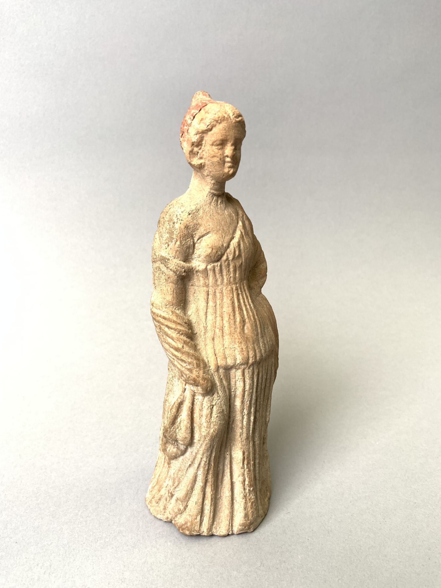 Belle statuette en terre cuite d'une courtisane. Elle est vêtue d'un drapé avec un [...]