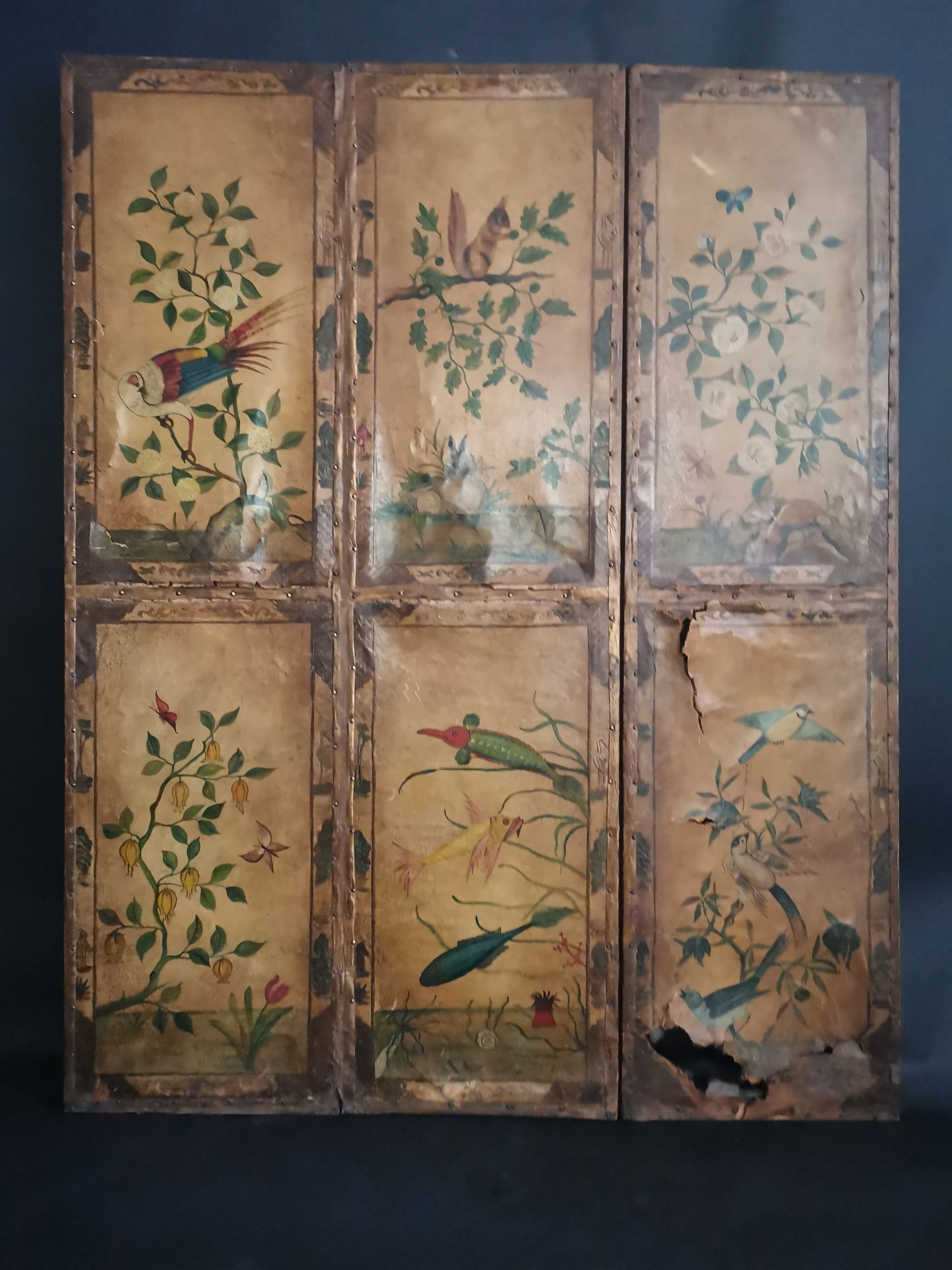 CHINE. Paravent à trois panneaux en cuir peint à décor de fleurs, végétaux, [...]